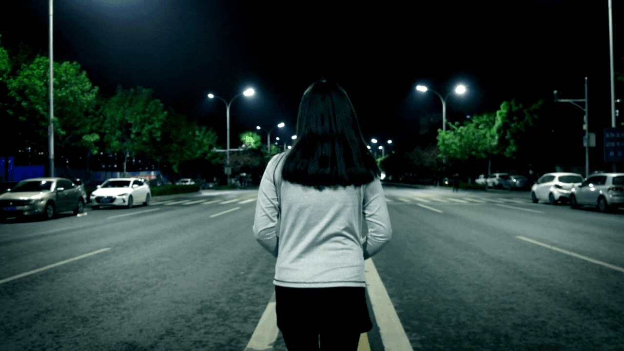 Lady walking in a dark lonely road